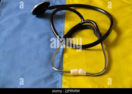 Le stéthoscope se trouve sur le drapeau national de l'Ukraine jaune-bleu, la loi martiale en Ukraine, les soins médicaux dans la guerre Banque D'Images