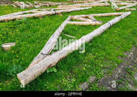 connexion à bande en acier forgé de poutres en bois pour cadre de poutre de support de toit posé sur l'herbe verte le jour de l'été Banque D'Images