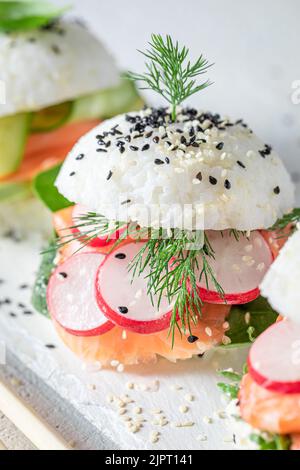 Hamburger à sushis unique et délicieux avec avocat et saumon comme hors-d'œuvre japonais. Sushi aux fruits de mer confectionnés de manière unique. Banque D'Images