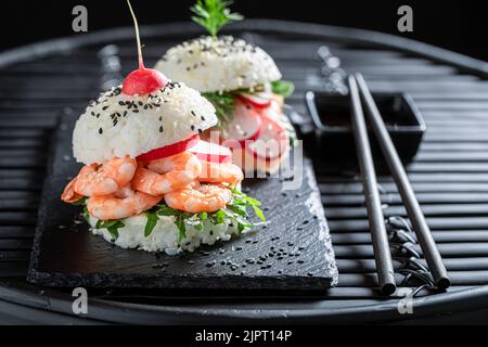 Hamburger à sushi sain et savoureux avec crevettes et poisson comme hors-d'œuvre japonais. Sushi aux fruits de mer confectionnés de manière unique. Banque D'Images
