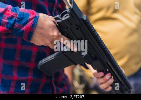 Gros plan des bras de l'homme tenant le pistolet Uzi. Formation sur les armes à feu. Prise de vue horizontale en extérieur. Photo de haute qualité Banque D'Images