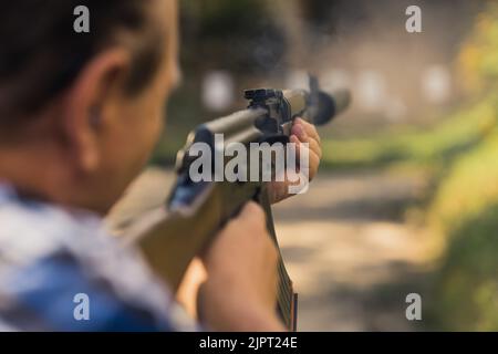 2022.08.07 Modlin, Pologne - vue arrière de l'entraînement de l'homme objectif sur la portée de tir en utilisant AK47. Premier plan flou. Prise de vue horizontale en extérieur. Photo de haute qualité Banque D'Images