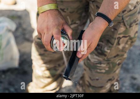 Gros plan du gunsmith dans des vêtements de camouflage pulvérisant le canon du canon. Maintenance du canon. Réparation de l'équipement militaire. Tir horizontal. Photo de haute qualité Banque D'Images