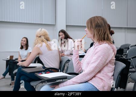 Au cours d'une conférence sur les mathématiques, les étudiants se rendent dans leurs affaires, sourient et se distrait. Banque D'Images