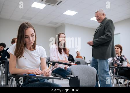 Un enseignant âgé d'une université technique donne une conférence aux étudiants de première année dans l'auditorium du collège. Banque D'Images