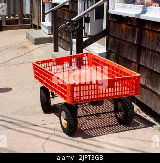 Un wagon rouge stationné sur la passerelle à l'extérieur d'un magasin dans Ocean Beach Village sur Fire Island. Banque D'Images