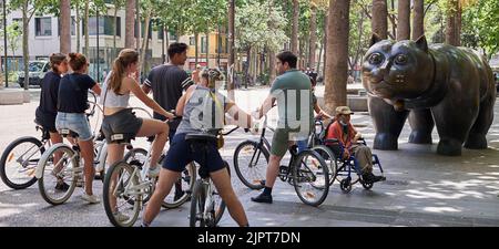 BARCELONE, ESPAGNE - 15 JUIN 2022: Groupe de touristes cyclistes regardant le chat de Fernando Botero dans la rambla de Barcelone. Banque D'Images