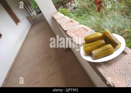 Concombres fermentés hongrois sur une assiette sur le mur d'une maison paysanne traditionnelle, Hongrie Banque D'Images