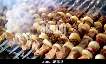 shish kebab de porc, sur des brochettes, frits sur des charbons. gros plan. Griller sur le charbon de bois et la flamme, pique-nique, nourriture de rue. Photo de haute qualité Banque D'Images