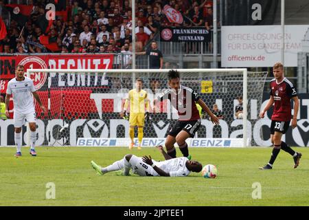 20 août 2022, Bade-Wurtemberg, Sandhausen: Football: 2. Bundesliga, SV Sandhausen - 1. FC Nürnberg, Matchday 5, BWT-Stadion am Hardtwald: Christian Kinsombi de Sandhausen est sur le sol avec une face déformée, tandis que Dario Dumic de Sandhausen (l), Jens Castrop de Nuremberg (M) et Christoph Daferner de Nuremberg se tiennent à côté de lui. Photo: Philipp von Ditfurth/dpa - NOTE IMPORTANTE: Conformément aux exigences du DFL Deutsche Fußball Liga et du DFB Deutscher Fußball-Bund, il est interdit d'utiliser ou d'utiliser des photographies prises dans le stade et/ou du match sous forme de séquence Banque D'Images