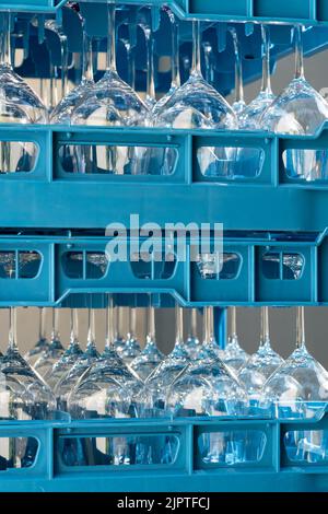 Boîtes en plastique bleu avec verres à vin brillants pour les restaurants à l'envers et reflétant la lumière Banque D'Images