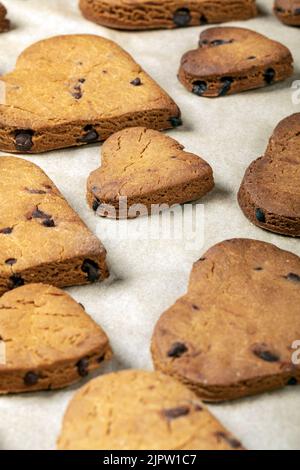 Biscuits en forme de coeur avec des gouttes de chocolat sur une plaque de cuisson Banque D'Images