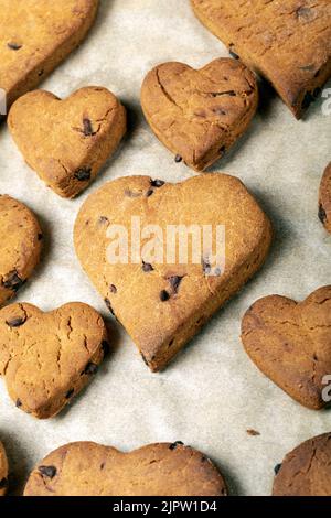 Biscuits en forme de coeur avec des gouttes de chocolat sur une plaque de cuisson Banque D'Images