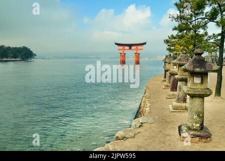 Torii du sanctuaire Miyajima et lanternes japonaises. Île d'Itsukushima, ville de Hatsukaichi, préfecture d'Hiroshima, Japon. Banque D'Images