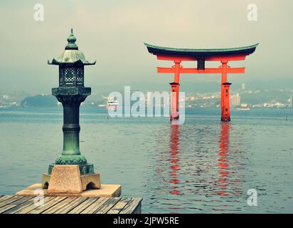 Lanterne en bronze et porte torii sur l'île Miyajima, Itsukushima, ville de Hatsukaichi, préfecture d'Hiroshima, Japon Banque D'Images