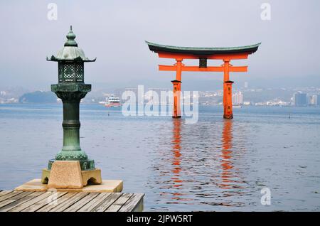 Lanterne en bronze et porte torii sur l'île Miyajima, Itsukushima, ville de Hatsukaichi, préfecture d'Hiroshima, Japon Banque D'Images