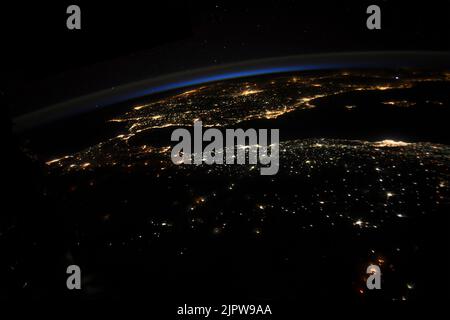 Un petit brin de lumière du jour reste quand le soleil se couche et les lumières de la ville brillent sur l'Afrique du Nord, l'Espagne et le droit de Gibraltar, 28 juillet 2022, de l'orbite de la Terre. Credit: Bob Hines/NASA/Alamy Live News Banque D'Images