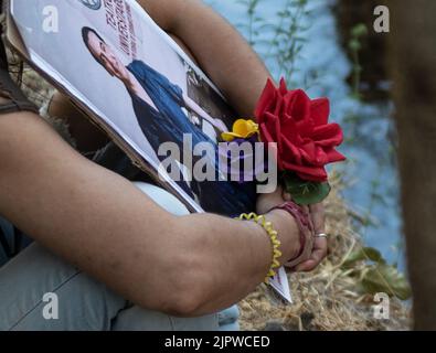 Femme tenant une photo de Federico Garcia Lorca avec des fleurs dans les couleurs du drapeau républicain rouge, jaune et violet Banque D'Images