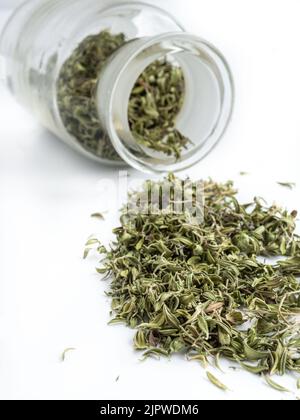Feuilles de thym séchées dans un pot sur fond blanc. Herbes pour la santé. Copier l'espace. Banque D'Images