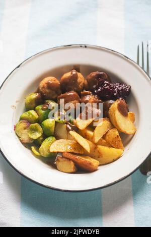 Boulettes de poulet aux pommes de terre rôties, aux choux de Bruxelles et au chou Banque D'Images
