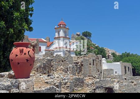 Église Agia Zoni, village abandonné Mikro Horio, Tilos, îles Dodécanèse, sud de la mer Égée, Grèce; avec une jolie urne en terre cuite en premier plan. May2022 Banque D'Images