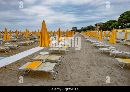 Plage vide sur la côte Adriatique. Parasols fermés chaises longues vides. Fin de la saison touristique Banque D'Images