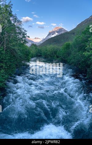 Une photo verticale de la rivière avec des montagnes en arrière-plan Banque D'Images