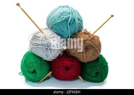 pelins colorés de fils de laine et aiguilles à tricoter en bois. Accessoires pour travaux d'aiguille sur fond blanc. Banque D'Images