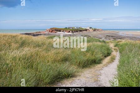 Un sentier se courbe et descend en bas du bord de Middle Eye vers l'île Hilbre en août 2022. Banque D'Images