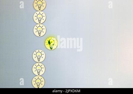 Ampoule à incandescence dans une rangée avec l'ampoule fluorescente centrale allumée. Concept de conservation de l'énergie Banque D'Images