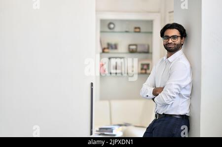 Souriant riche et réussi, le jeune homme d'affaires indien se tient au bureau, dans un portrait. Banque D'Images