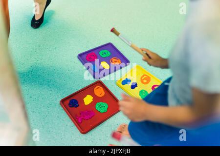 École maternelle. Les tout-petits ayant des cours de jeu d'art, utilisant des peintures et des brosses lavables et non toxiques. Activités artistiques amusantes pour les enfants compétences fines et brutes, créativité et développement de l'imagination. Photo de haute qualité Banque D'Images