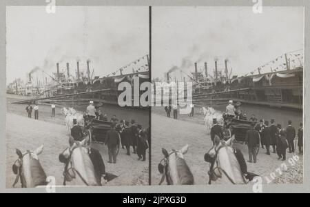 Theodore Roosevelt assis dans une charriot tiré par des chevaux en signe de main au public avec son chapeau. De nombreux bateaux à vapeur sont amarrés le long de la rive Banque D'Images
