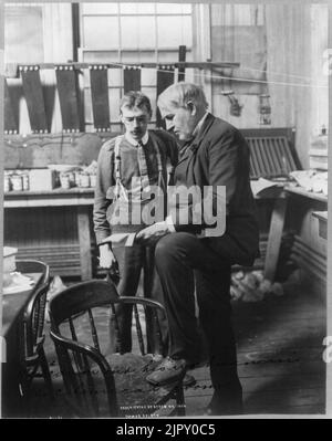 Thomas Alva Edison, 1847-1931, portrait en pied, debout, face à la gauche, avec son ouvrier dans l'industrie chimique prix Banque D'Images