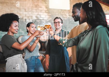 Dégustation de vins entre amis, en dégustant des cheers et des toasts, célébrez avec des verres de champagne dans la cave, la distillerie et la brasserie. Groupe de heureux, diversité et sourire Banque D'Images