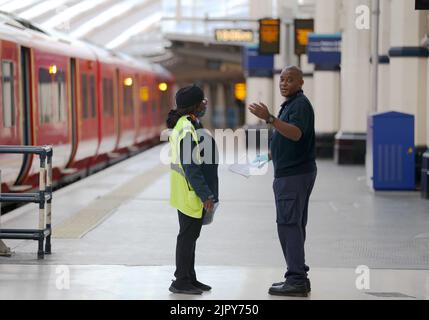 (220821) -- LONDRES, le 21 août 2022 (Xinhua) -- les membres du personnel parlent à la gare de Waterloo, à Londres, en Grande-Bretagne, le 20 août 2022. Cet été, alors que de nombreux Britanniques optaient pour une escapade et que les centres de transport à travers le Royaume-Uni étaient déjà sous pression, une autre série de grèves a jeté les transports publics dans le chaos cette semaine. Plus de 50 000 travailleurs des réseaux de chemin de fer, de métro et d'autobus ont été en grève sur les salaires et les conditions de travail de jeudi jusqu'au week-end. Il est conseillé aux passagers de voyager uniquement en train si nécessaire. POUR ALLER AVEC « Feature: Les plans de voyage ont été interrompus au Royaume-Uni comme St Banque D'Images