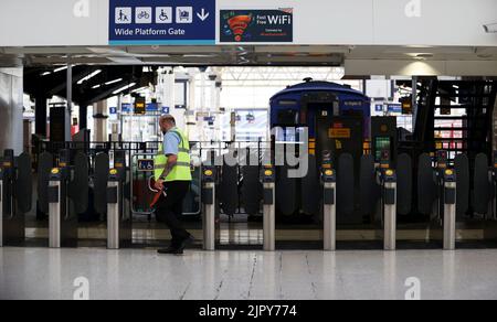 (220821) -- LONDRES, le 21 août 2022 (Xinhua) -- Un membre du personnel se tient à côté des portes d'entrée de la gare de Waterloo, à Londres, en Grande-Bretagne, le 20 août 2022. Cet été, alors que de nombreux Britanniques optaient pour une escapade et que les centres de transport à travers le Royaume-Uni étaient déjà sous pression, une autre série de grèves a jeté les transports publics dans le chaos cette semaine. Plus de 50 000 travailleurs des réseaux de chemin de fer, de métro et d'autobus ont été en grève sur les salaires et les conditions de travail de jeudi jusqu'au week-end. Il est conseillé aux passagers de voyager uniquement en train si nécessaire. POUR ALLER AVEC 'Feature: Travel pla Banque D'Images