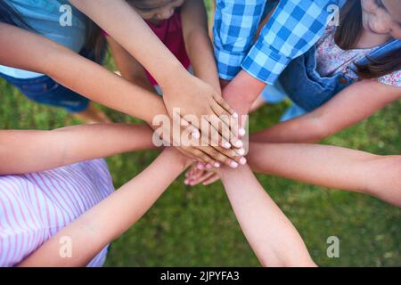 Faites en sorte que tout le monde se sente comme quelqu'un. Un groupe d'enfants se superportant les mains les unes aux autres. Banque D'Images