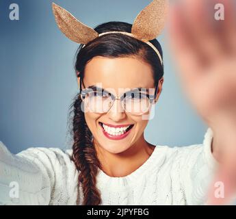 Ces oreilles de lapin me mettent dans une telle humeur. Photo en studio d'une jeune femme portant des oreilles de lapin déguissées sur un fond Uni. Banque D'Images