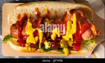 Un délicieux sandwich hot dog avec des légumes frais, de la moutarde et du catap sur une table Banque D'Images