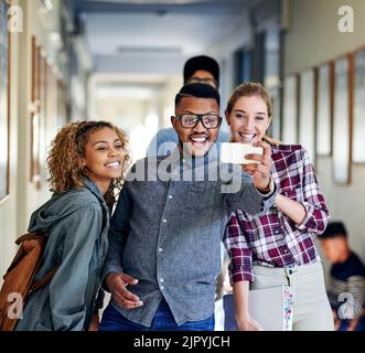 Prenons un selfie, un groupe de jeunes étudiants de l'université qui prennent des selfies sur le campus. Banque D'Images