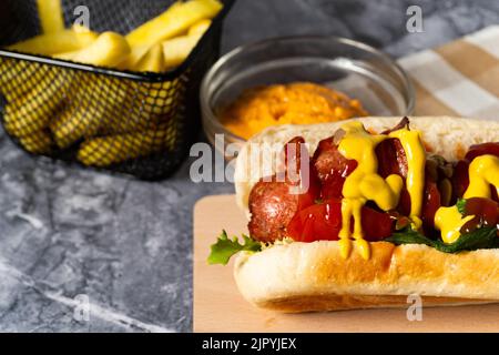 Un hot dog savoureux avec des frites et de la sauce au fromage Banque D'Images