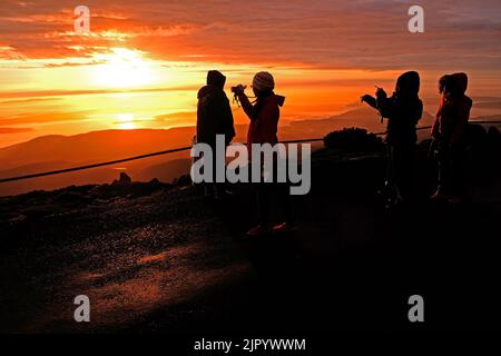 Touristes regardant le lever du soleil depuis le sommet de kunanyi/Mt Wellington à Hobart, Tasmanie (altitude 1271 mètres au-dessus du niveau de la mer) Banque D'Images