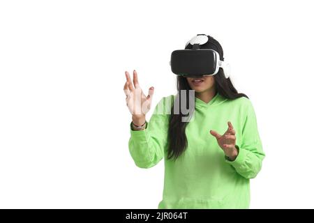 Stupéfait femme vénézuélienne touchant l'air pendant l'expérience VR, isolé. Banque D'Images