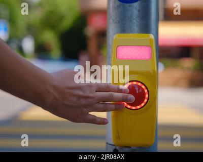 Gros plan d'un bouton de signalisation de passage de côté pris à un passage à niveau contrôlé par des piétons. Bouton-poussoir manuel pour traverser Banque D'Images