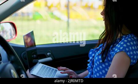 artiste, belle femme brune, assis en voiture, dessine un croquis au crayon, un bouquet de pissenlits jaunes. dessin de la nature, le processus créatif du dessin. été. Photo de haute qualité Banque D'Images