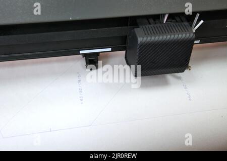 Robot informatisé pour l'écriture automatique avec un stylo. Boutique de couture. Le marquage des matériaux est automatisé. Bras robotique avec dessin au stylo noir. Banque D'Images