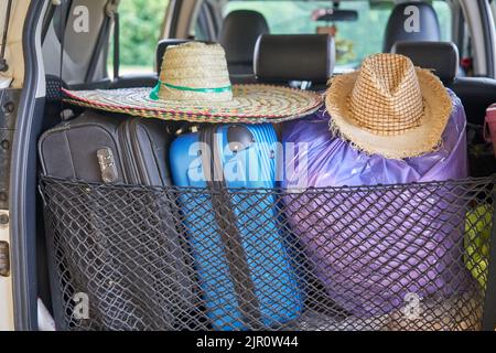 Une voiture prête à voyager, avec des chapeaux de soleil et des valises. Banque D'Images