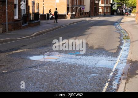 À la fin de la sécheresse de 2022, un tuyau d'eau qui éclate sur la route Winchester provoque un déversement d'eau sur la route et une perte dans le drain. Basingstoke. ROYAUME-UNI Banque D'Images