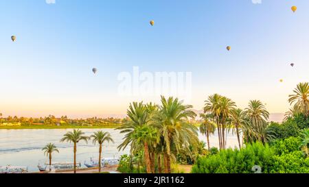 Ballons d'air chaud se levant tôt le matin de la rive ouest de Louxor, en Égypte Banque D'Images